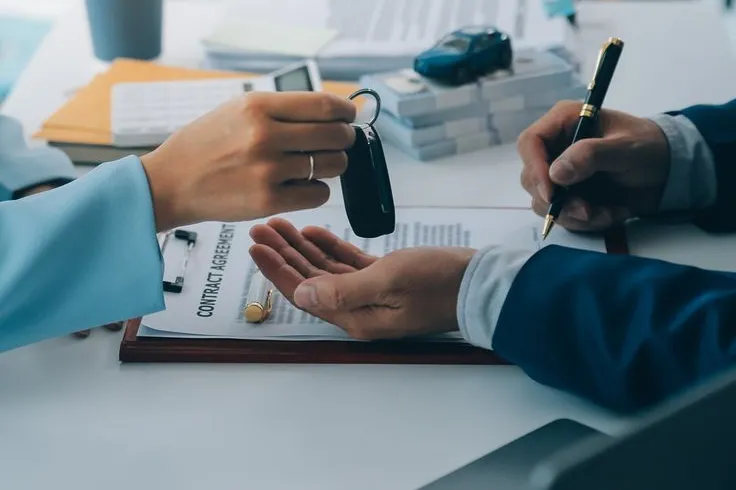 Car keys handed over as a borrower signs a Regional Finance auto-secured loan agreement